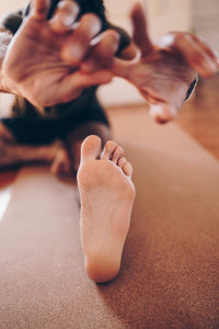 Tapete Yoga em cortiça - grande plano de um pé num alongamento durante aula de ioga
